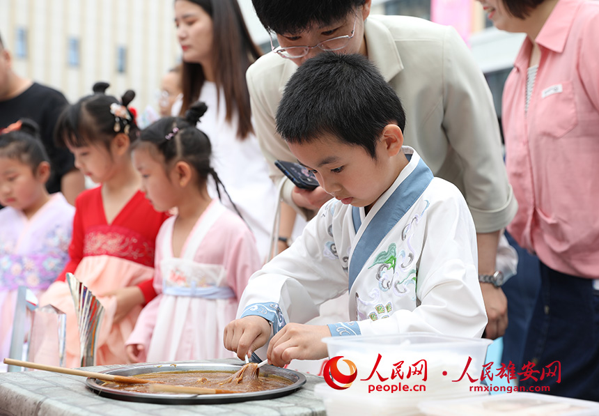 5月31日，雄安容和樂安幼兒園舉辦傳統文化游園活動?；顒友埩诵郯伯數胤沁z文化傳承人走進幼兒園，與孩子和家長交流互動。通過現場接觸非遺項目，讓孩子們零距離認識非遺、熟悉非遺，感受非遺之美。人民網 李兆民攝