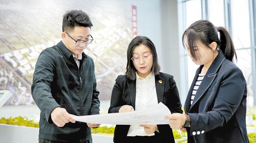 2024年2月，在北京非首都功能疏解中心，夏雨（中）與同事探討項目規(guī)劃。受訪者供圖